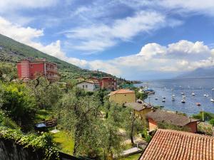 a town on a hill with boats in the water at Residence Casa Maria in Assenza di Brenzone