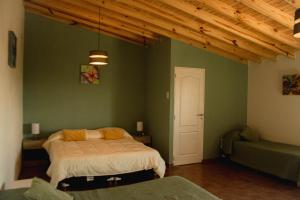 a bedroom with two beds and a green wall at Hosteria Casa kuyen in El Calafate +28 photos