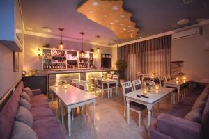 a restaurant with tables and chairs and a bar at Republic Square In Hotel California in Yerevan
