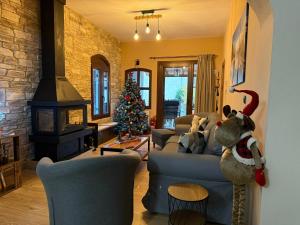 a living room with a christmas tree and a blue couch at Cozy Nest - Polydrosos Escape in Polydrossos