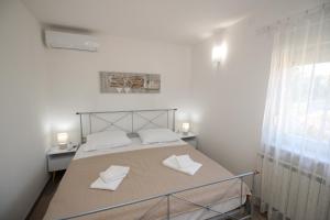 a bedroom with a bed with two white towels on it at Sea side Punat in Punat