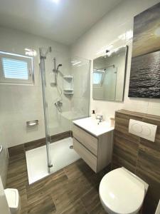 a bathroom with a shower and a toilet and a sink at Sea side Punat in Punat +38 photos