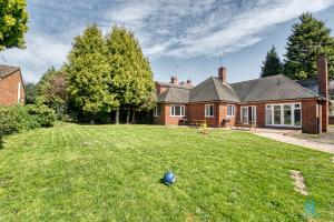 a house with a yard with a ball in the grass at 4 Bedrooms- Sleeps 8 in Kidderminster