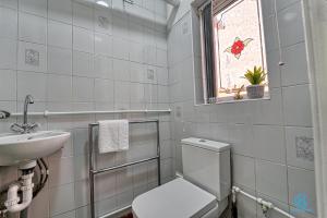 a bathroom with a toilet and a sink and a window at 4 Bedrooms- Sleeps 8 in Kidderminster +19 photos