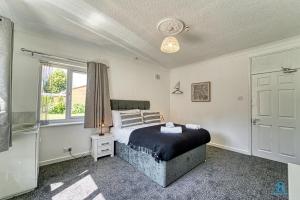 a bedroom with a bed and a window at 4 Bedrooms- Sleeps 8 in Kidderminster