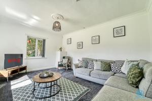 a living room with a couch and a table at 4 Bedrooms- Sleeps 8 in Kidderminster
