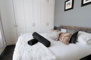 a white bed with pillows on top of it at Meldon Cottage with Private Hot Tub in Newbiggin-by-the-Sea