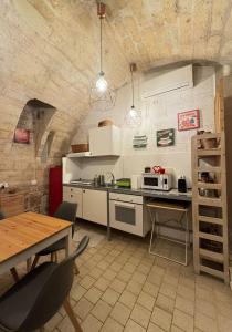 a kitchen with white appliances and a table with chairs at La torretta del SUD in Bisceglie
