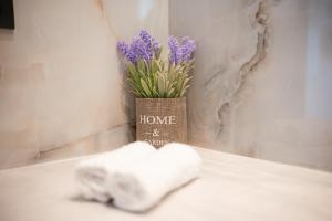 a vase of purple flowers sitting next to a towel at Aurora 3 - Family Comfort near the beach in Marmari +36 photos