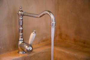 a water faucet with a roll of toilet paper at Stavlos Cottage in Vasiliki +76 photos