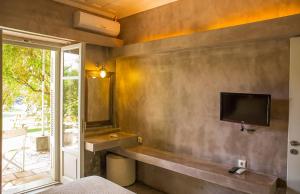 a bedroom with a tv on the wall at Stavlos Cottage in Vasiliki