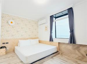 a bed in a small room with a window at Stay Hotel in Xiaoliuqiu