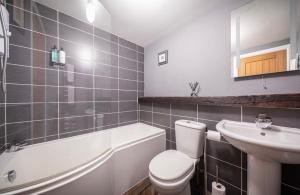 a bathroom with a white toilet and a sink at Home Farm Apartments in Portree +35 photos