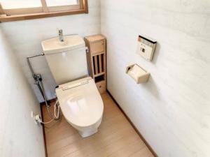 ein kleines Badezimmer mit Toilette in einem Zimmer in der Unterkunft Seminare in Karuizawa
