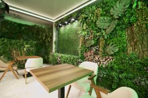 a room with a green wall with a table and chairs at Forty Nişantaşı Hotel & SPA in Istanbul