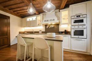 a kitchen with white cabinets and white appliances at Prugnolo Grand View in Montepulciano