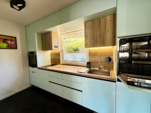 a kitchen with white cabinets and a sink and a window at Traum Berg - Koppelberg 2 in Traben-Trarbach +22 photos