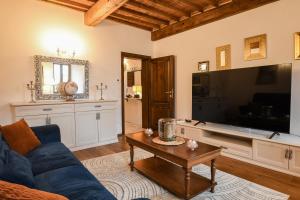 a living room with a blue couch and a tv at Prugnolo Grand View in Montepulciano