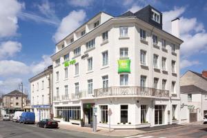 a white building with a green sign on it at ibis Styles Saumur Gare Centre in Saumur