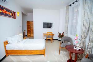 a bedroom with a bed and a table and a desk at Timeless Residency in Zanzibar City