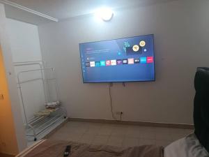 a flat screen tv hanging on a white wall at Chambre aménagée dans un hôtel in Douala