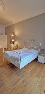 a white bed in a room with a wooden floor at Le Relais - Appart'Hotel in Düsseldorf +10 photos