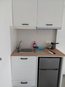 a kitchen with white cabinets and a sink at Kedros -Small Seaside Studio -Ground Floor in Elafonisos