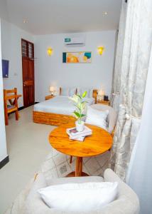 a bedroom with a bed and a wooden table with a table sidx sidx at Timeless Residency in Zanzibar City