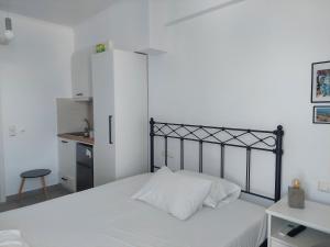 a bedroom with a white bed and a white cabinet at Kedros -Small Seaside Studio -Ground Floor in Elafonisos +5 photos