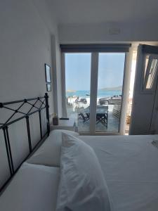 a bedroom with a bed and a view of a patio at Kedros -Small Seaside Studio -Ground Floor in Elafonisos