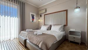 a bedroom with a bed with two towels on it at Hotel Pitsakis in Tolo