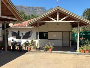 a house with a porch with potted plants at New Hambala Homestay in Attigundi