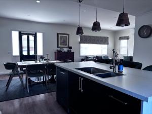 a kitchen and living room with a sink and a table at Queensly Cottage in Portland