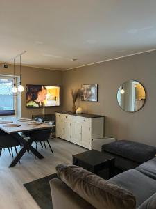 a living room with a table and a dining room at Modern & Central - Free Parking & Stylish Decor in Vossevangen