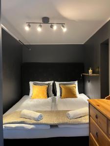 a bedroom with a large bed with yellow pillows at Modern & Central - Free Parking & Stylish Decor in Vossevangen
