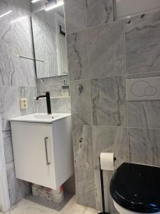 a bathroom with a white toilet and a black seat at Modern & Central - Free Parking & Stylish Decor in Vossevangen +19 photos
