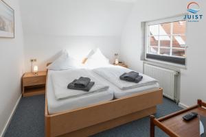 a bedroom with a bed with two bags on it at Töwerland Zimmer 7 in Juist