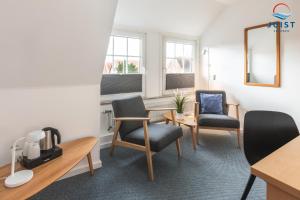 a waiting room with two chairs and a table and a mirror at Töwerland Zimmer 7 in Juist