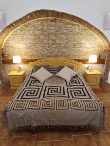a bedroom with a bed with a brick wall at Nick's Cave, Bed and Breakfast with a difference in Cuevas del Almanzora