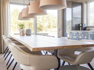 a dining room with a large wooden table and chairs at Luxurious villa for 8 people in De Cocksdorp Texel in De Cocksdorp