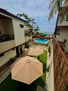 an overhead view of a patio with an umbrella and a pool at Elmarie Beach Resort in San Fabian