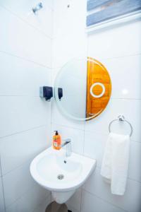 a white bathroom with a sink and a mirror at Timeless Residency in Zanzibar City +25 photos