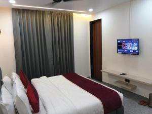 a bedroom with a bed and a tv on the wall at Hotel The Crown Prince in Jaipur