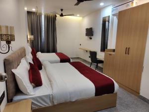 a hotel room with two beds and a desk at Hotel The Crown Prince in Jaipur +30 photos