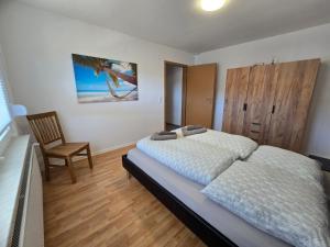 a bedroom with a bed and a chair in it at Ferienwohnung Baj in Albstadt +10 photos