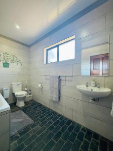 a bathroom with a sink and a toilet at Vaal Dam Manor - Waters Edge in Oranjeville +31 photos