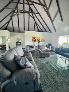 a living room with couches and a glass table at Vaal Dam Manor - Waters Edge in Oranjeville