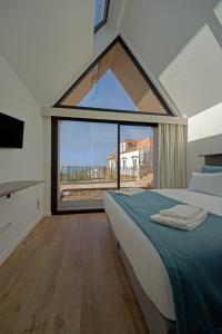 a bedroom with a bed and a large window at Boomerang d'O Século in Ericeira