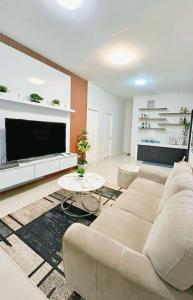 a living room with a couch and a tv at Jumira Staycation in Tagum +24 photos