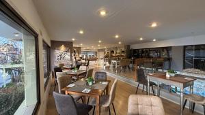 a restaurant with wooden tables and chairs and a room at Hotel Pitsakis in Tolo